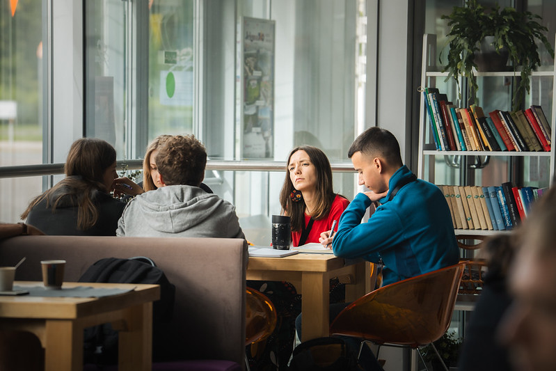 Photo of 4 students discussing around a table